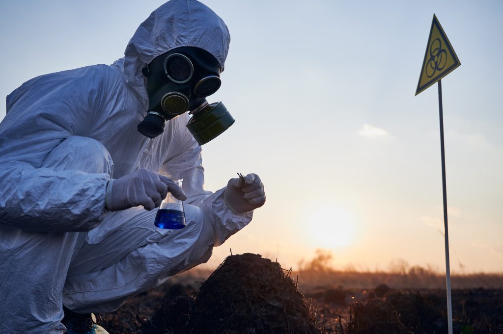 Scientist collecting samples in hazardous area.